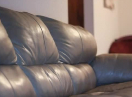 امرأة سمراء مفلس مع جلد شاحب ينتشر ساقيها وتسمر على الأريكة
